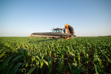 Traktör tarlada böcek ilacı kimyasallarıyla gübreleme yapıyor. 
