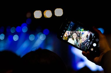 Konserde gülümseyen iki genç kızın selfie 'si. Akşamları iyi vakit geçiririz..