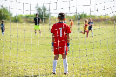 Spor stadyumunda futbol takımı yarışması. Futbol kalesi ve kaleci ön planda.