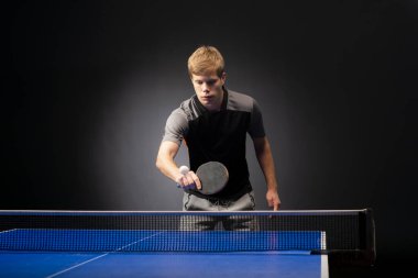 Siyah arka planda tenis oynayan genç adamın portresi