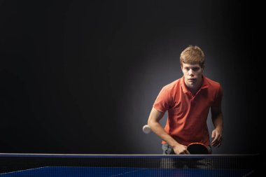 Siyah arka planda tenis oynayan genç adamın portresi