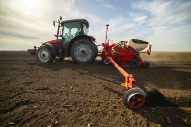 Traktör tohumu olan çiftçi - ilkbaharda tarım tarlalarına ekin ekiyor.
