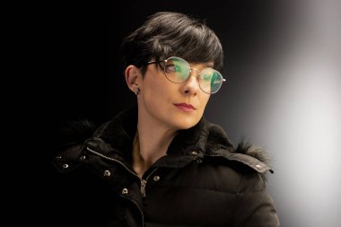 Siyah kısa saçlı, gözlük takan genç ve güzel bir kadının portresi.. 