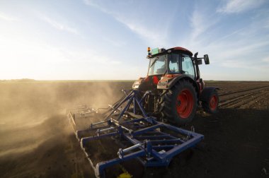 Traktör tarlada çalışıyor, tarlayı ekime hazırlıyor, tarlayı sürüyor.