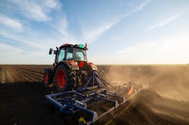 Traktör tarlada çalışıyor, tarlayı ekime hazırlıyor, tarlayı sürüyor.
