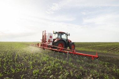Traktör tarlada böcek ilacı kimyasallarıyla gübreleme yapıyor. 