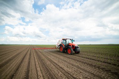 Traktör tarlada böcek ilacı kimyasallarıyla gübreleme yapıyor. 