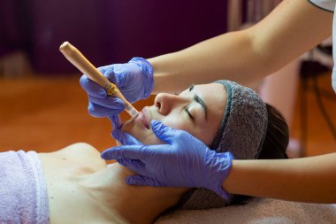 Spa, tatil köyü, güzellik ve sağlık konsepti. Güzellik salonunda yüz bakımı gören güzel bir kadın. Yüz bakımı. Kozmetoloji 