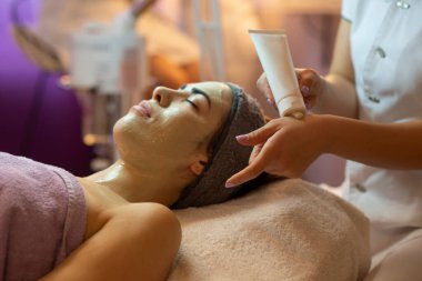 Yüz soyma maskesi, kaplıca güzellik tedavisi, cilt bakımı. Güzellik salonundaki kadın yüz bakımını alıyor. Yan görüş, yakın çekim.