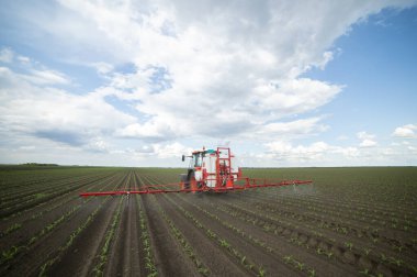 Traktör tarlada böcek ilacı kimyasallarıyla gübreleme yapıyor. 