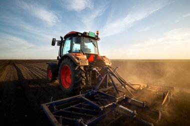 Traktör tarlada çalışıyor, tarlayı ekime hazırlıyor, tarlayı sürüyor.