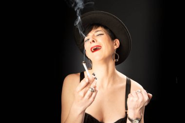 Siyah arka planda siyah şapkalı, akli dengesi yerinde olmayan genç bir kadın. Kötü duygular kavramı.