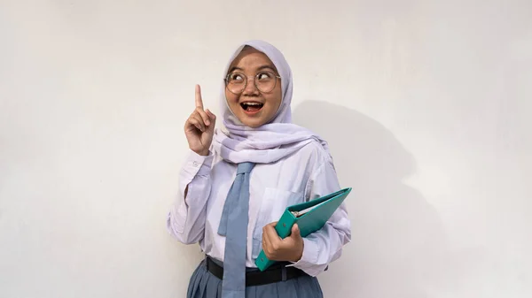 ノートに白とグレーの制服を着たインドネシアの女子高生がアイデアを出していました 白い背景に孤立したイメージ — ストック写真