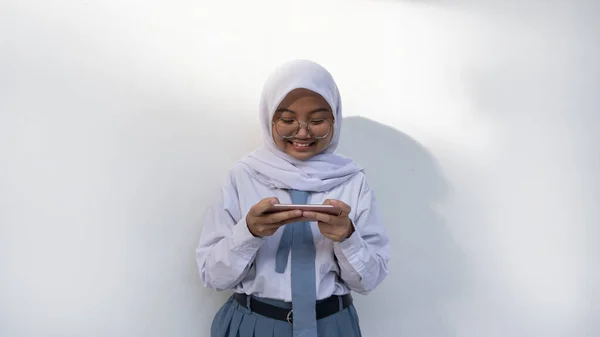灰色と白の制服を着たインドネシアの女性高校生が電話を見てショックを受け 動揺し 混乱しました — ストック写真