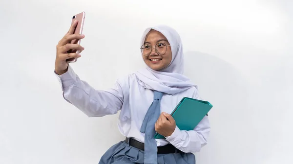 灰色と白の制服を着たインドネシアの女性高校生 手で頭を保持し 何かを見下ろす非常に深く考えるネクタイとヒジャブ — ストック写真