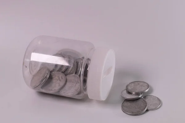 Paralar cam izole üzerinde beyaz arka plan kavanoz. Kaydetme para kavramı.