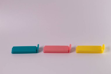 Beyaz arka planda izole edilmiş mavi-pembe-sarı plastik besin torbası makası bileşimi. Mini klip plastik yiyecek.