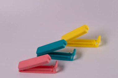 Beyaz arka planda izole edilmiş mavi-pembe-sarı plastik besin torbası makası bileşimi. Mini klip plastik yiyecek.