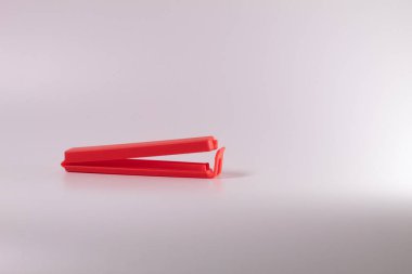 Kırmızı plastik yemek torbası makası beyaz arka planda izole edilmiş..