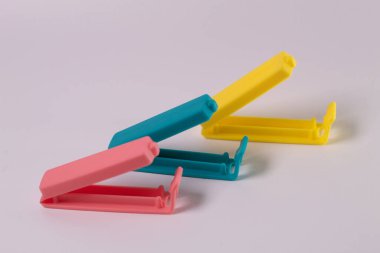 Beyaz arka planda izole edilmiş mavi-pembe-sarı plastik besin torbası makası bileşimi. Mini klip plastik yiyecek.