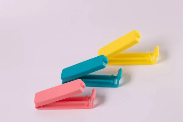 Beyaz arka planda izole edilmiş mavi-pembe-sarı plastik besin torbası makası bileşimi. Mini klip plastik yiyecek.