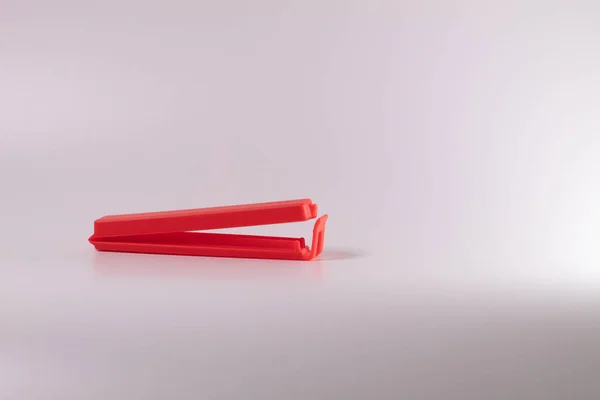 Kırmızı plastik yemek torbası makası beyaz arka planda izole edilmiş..