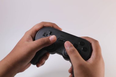 Tangerang Selatan, Endonezya - 21 Mart 2023: Beyaz arka planda el altında oyun kontrolörü. 8bitdo joystick