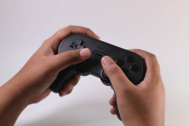 Tangerang Selatan, Endonezya - 21 Mart 2023: Beyaz arka planda el altında oyun kontrolörü. 8bitdo joystick