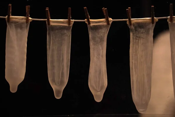 Många Preventivmedel Kondomer Hängande Ett Rep Isolerad Svart Bakgrund — Stockfoto