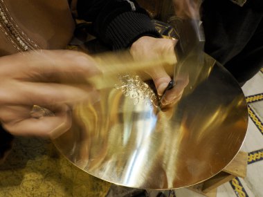 Metal craftsman making copper trays in Fes Morocco