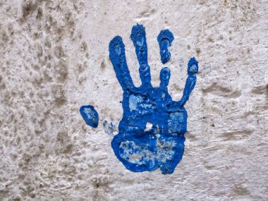Blue Colorful Hand print on white wall detail
