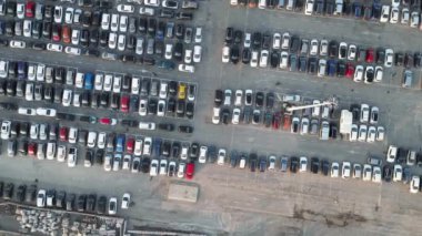 Aerial view over huge outdoor parking lots with many cars and vehicles