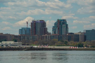 WASHINGTON DC, ABD - 29 Mart 2023 Ronald Reagan Ulusal Havaalanı 'ndan bir uçak jeti kalkıyor. Havaalanının arkasındaki binalar Potomac nehrinin arka planında görülüyor