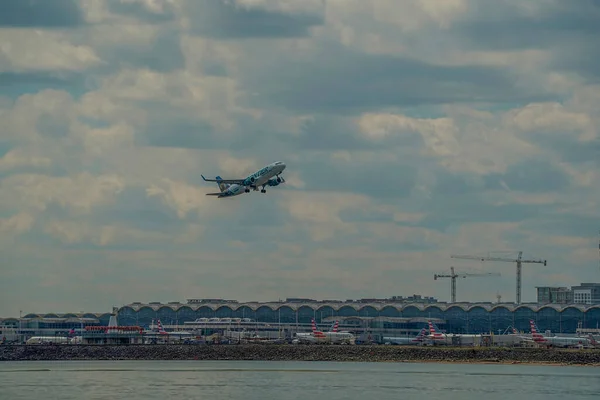 ワシントンDc 2023年3月29日航空機のジェットがロナルド レーガン国立空港から離陸しています ポトマック川を背景に空港の後ろの建物が見えます — ストック写真