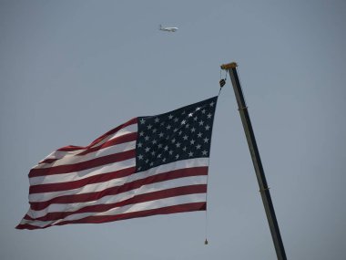 Mavi gökyüzü ve bir uçağa karşı Amerikan bayrağı