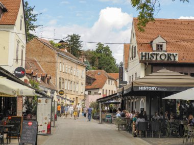 ZAGREB, CROATIA - 9 Ağustos 2023 - Zagreb 'in Hırvat mimari kent binasının ana meydanında yemek yiyen turist