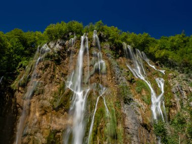 Hırvatistan 'ın Plitvice Gölleri Ulusal Parkı' ndaki su gölleri ve güzel şelalelerin yaz manzarası