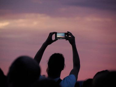 Kızıl günbatımını fotoğraflayan bir sürü insan