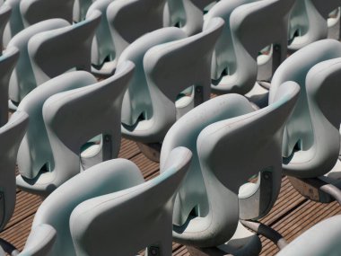 Açık hava amfi tiyatrosunda numaralandırılmış boş plastik koltuklar. Pek çok seyirci açık tiyatro koltukları.