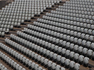 Açık hava amfi tiyatrosunda numaralandırılmış boş plastik koltuklar. Pek çok seyirci açık tiyatro koltukları.