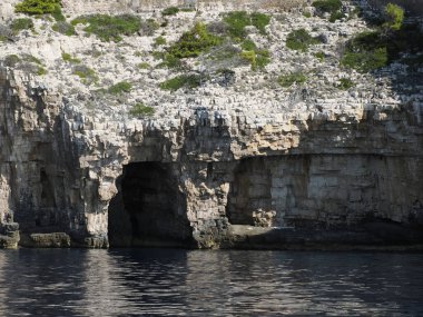 Hırvatistan adası turkuvaz su ve kaya uçurumları, berrak bir yaz gününde şeffaf berrak deniz suyu
