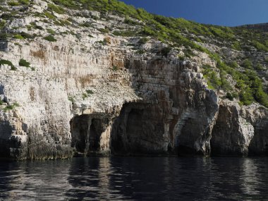 Hırvatistan adası turkuvaz su ve kaya uçurumları, berrak bir yaz gününde şeffaf berrak deniz suyu