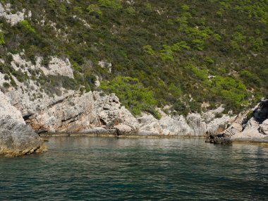 Hırvatistan adası turkuvaz su ve kaya uçurumları, berrak bir yaz gününde şeffaf berrak deniz suyu