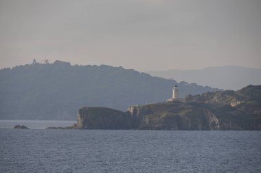 Langoustier 'in önündeki deniz feneri kırmızı plajı Porquerolles Adası Fransa manzarası.