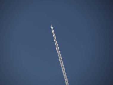 Dağdaki mavi gökyüzünde bir jet yolu.