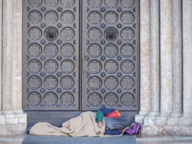 İtalya 'nın Trento kentindeki San Vigilio Ortaçağ Katedrali' nin girişinde uyuyan evsiz bir serseri.