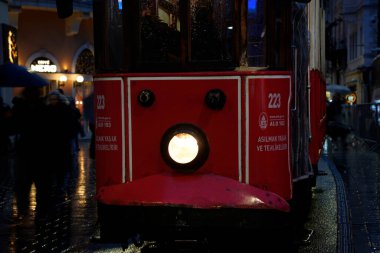 İSTANBUL, TURKEY - 5 HAZİRAN 2022: İstanbul 'un en ünlü caddelerinden birinden geçen tarihi kırmızı tramvay - İstiklal Caddesi, Taksim bölgesi.