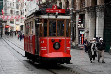 İSTANBUL, TURKEY - 5 HAZİRAN 2022: İstanbul 'un en ünlü caddelerinden birinden geçen tarihi kırmızı tramvay - İstiklal Caddesi, Taksim bölgesi.