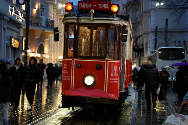 İSTANBUL, TURKEY - 5 HAZİRAN 2022: İstanbul 'un en ünlü caddelerinden birinden geçen tarihi kırmızı tramvay - İstiklal Caddesi, Taksim bölgesi.