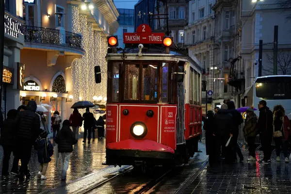 İSTANBUL, TURKEY - 5 HAZİRAN 2022: İstanbul 'un en ünlü caddelerinden birinden geçen tarihi kırmızı tramvay - İstiklal Caddesi, Taksim bölgesi.